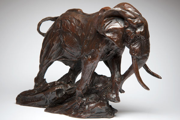 Bronze sculpture of an African elephant with detailed skin texture and long tusks.